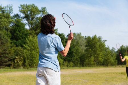 Teen Boy Serving in a Family Badminton Gameの写真素材