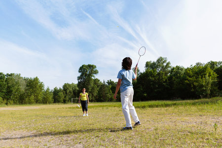 Woman Picking Up Shuttlecock During Badmintonの写真素材