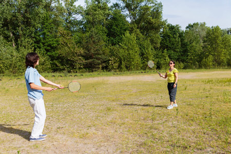 Teen Boy Serving Badminton Outdoorsの写真素材