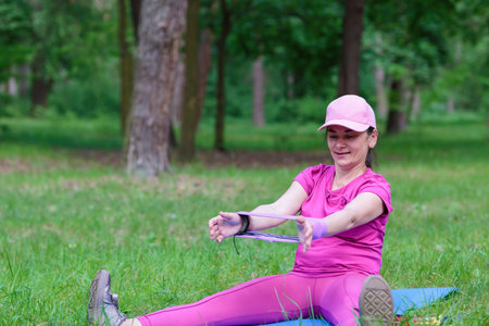 Woman exercising with a resistance band in the parkの写真素材