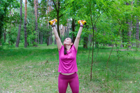 Mature Woman Smiling While Exercising with Dumbbellsの写真素材