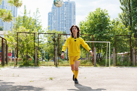Teen soccer player juggling ball during practiceの写真素材
