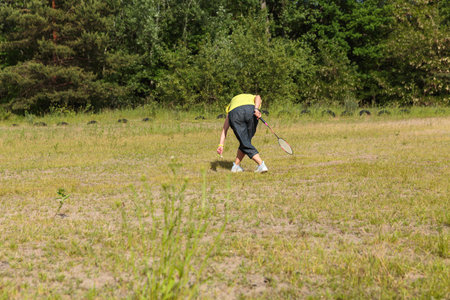 Woman Picking up a Shuttlecock on the Fieldの写真素材