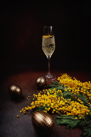 Festive Easter champagne with decorated eggs and mimosaの写真素材