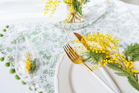 Elegant spring dining table with mimosa flowers and champagne glassの写真素材