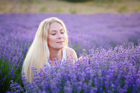 Woman walking between rows of lavender flowers and posingの写真素材