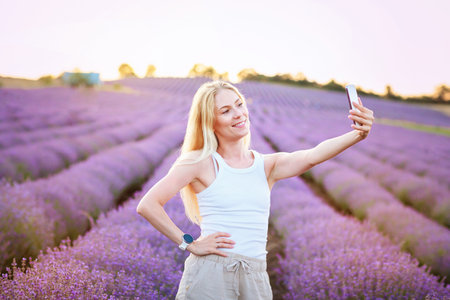 Woman taking selfie in lavender fieldの写真素材