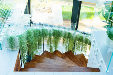 Stylish spiral staircase with green plant decorationの写真素材