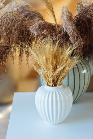 Elegant dried wheat bouquet in white ceramic vaseの写真素材