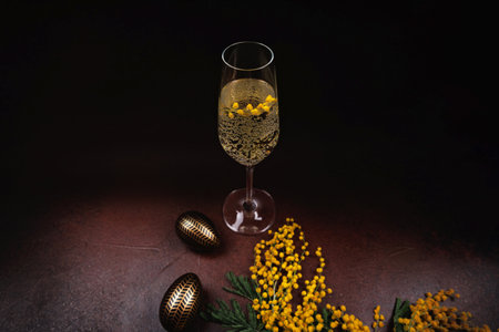 Festive Easter champagne with mimosa flowers and decorative eggsの写真素材