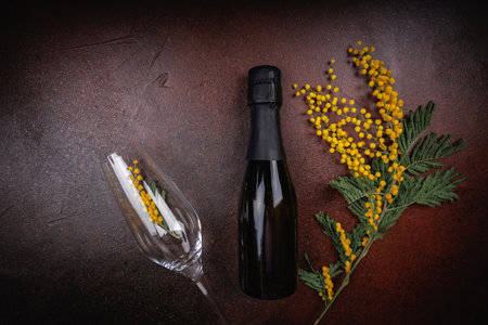 Champagne Bottle and Glass with Mimosa Flowersの写真素材