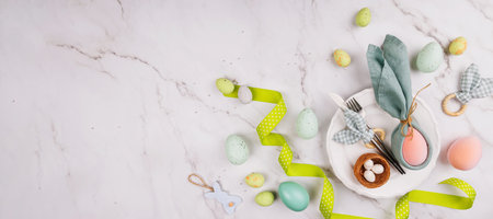 Easter Plate Setting with Bunny Napkin and Pastel Eggsの写真素材