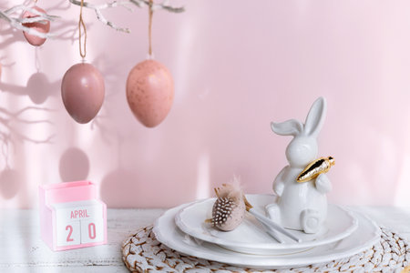 Table place setting with easter bunny figure, eggs and wooden Perpetual calendarの写真素材
