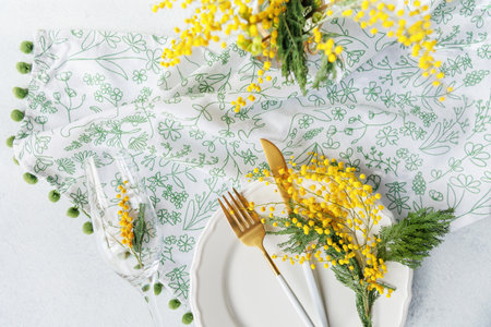 Festive spring table arrangement with mimosa in a glassの写真素材