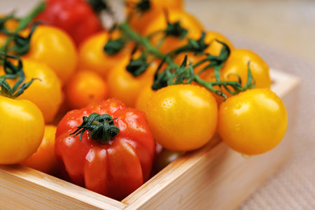 Fresh tomatoes in wooden box for healthy cookingの写真素材