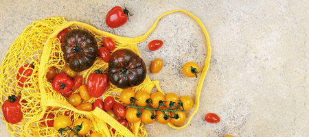 Cherry and heirloom tomatoes in reusable grocery bagの写真素材