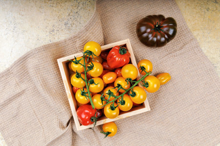 Fresh yellow and red cherry tomatoes in wooden boxの写真素材
