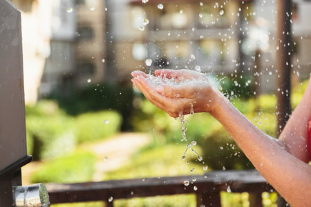 Water Flowing Into Hands During Outdoor Showerの写真素材