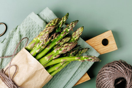 Flat Lay of Green Asparagus on Kitchen Boardの写真素材