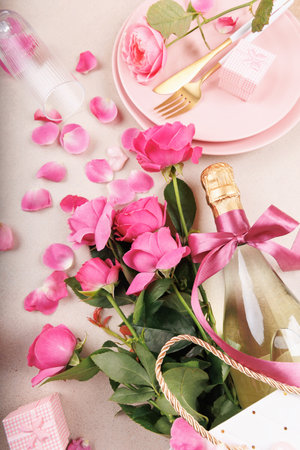 Romantic table setting with pink roses and champagne bottleの写真素材