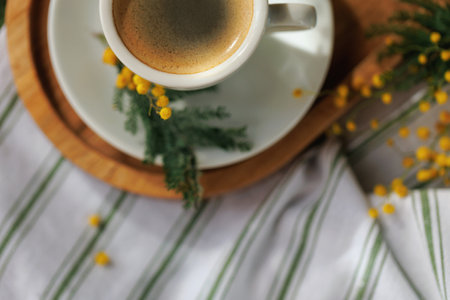 Close-up of espresso cup with mimosa flowers on trayの写真素材