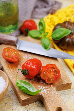 Gourmet kitchen scene with fresh tomatoes, salt and basil leavesの写真素材