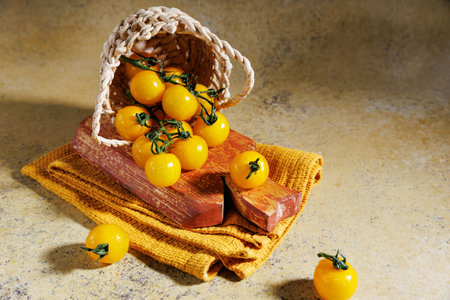 Top view of yellow cherry tomatoes spilling from basketの写真素材