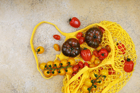 Overhead view of tomatoes in mesh shopping bagの写真素材