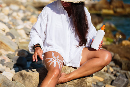Mature Woman Drawing Sun with Sunscreenの写真素材