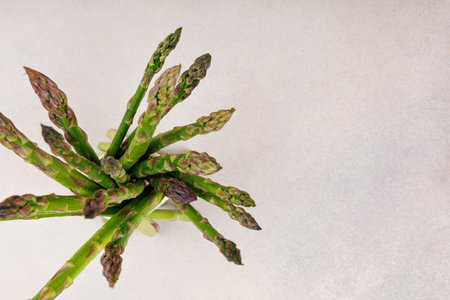 Top view of fresh green asparagus bundle on neutral background