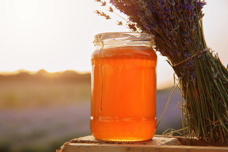 Jar of lavender honey with fresh bouquet at sunsetの写真素材