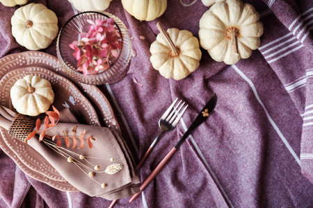 Cozy autumn dining table with pumpkins and rustic tablewareの写真素材