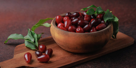 Fresh Cornelian Cherries in Rustic Wooden Bowlの写真素材