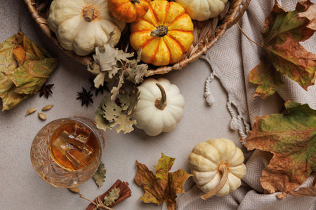 Flatlay of whiskey and pumpkins with autumn leaves..の写真素材