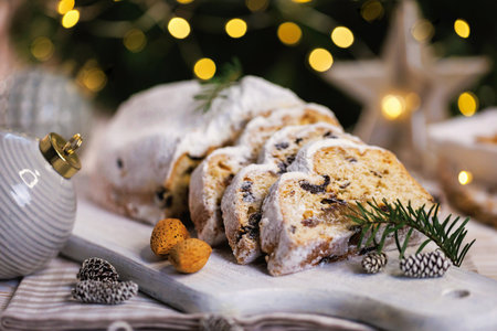 Sliced Christmas stollen on festive wooden serving boardの写真素材