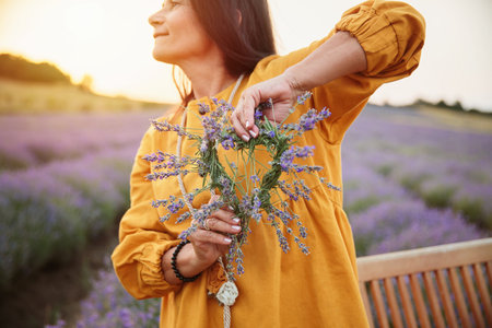 Woman smiling with lavender wreath in her handsの写真素材