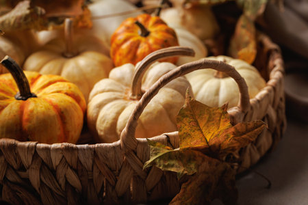 Pumpkins and fall leaves in cozy rustic basketの写真素材