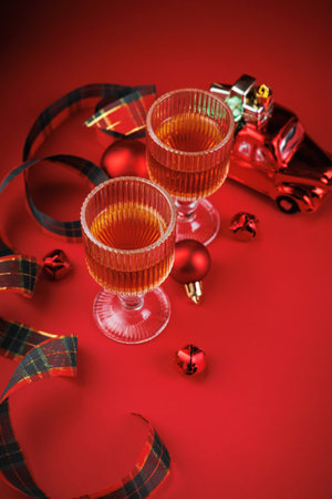 Top view of whiskey glasses and Christmas decor on red backgroundの写真素材