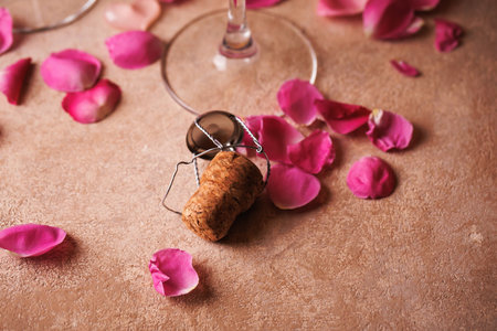 Champagne Cork with Rose Petals on Rustic Tableの写真素材