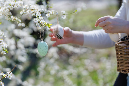 Spring Easter tree decorating with hands and basket