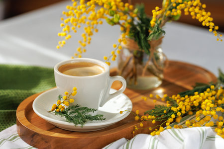Springtime coffee with mimosa flowers and soft light