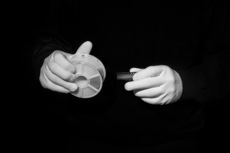 laboratory, hands in white gloves hold a black and white film, darkroom, film developmentの写真素材