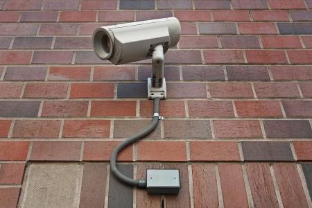cctv security video camera  on outside wall of a buildingの写真素材
