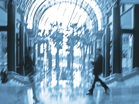 abstract image of a business people  walking in the lobby in intentional motion blur and a blue tint