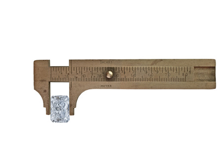 diamond in vintage heavy patina brass caliper over whiteの写真素材