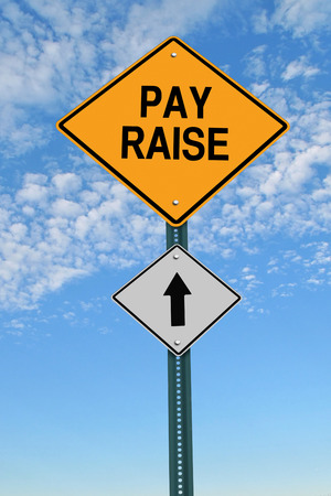 pay raise ahead road sign over blue sky with cloudsの写真素材