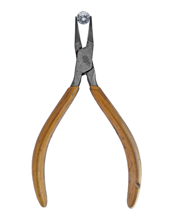 vintage pliers holding a gem diamond over white backgroundの写真素材