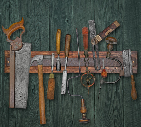 vintage woodworking tools on a magnetic rack against the wooden wallの写真素材