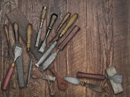 faded colors of a set of vintage chisels and sharpening stones, strop over wooden bench, space for your textの写真素材