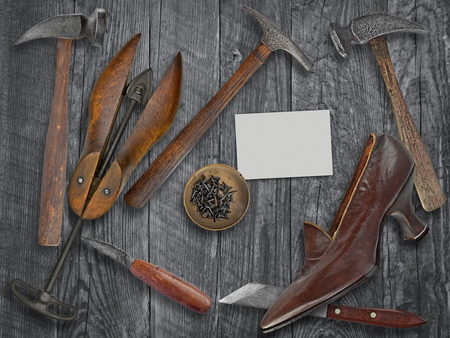 vintage ladies shoe and shoemakers tools over wooden table, space for your text on a blank business cardの写真素材